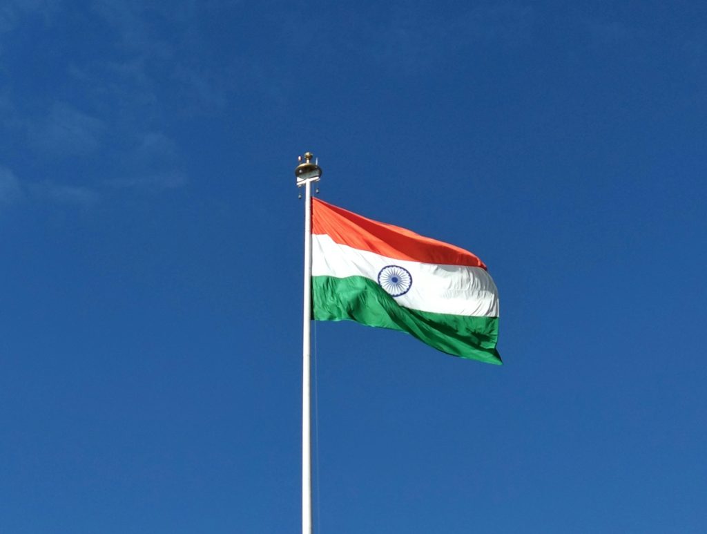 Flag of India waving in the breeze with a clear sky background.