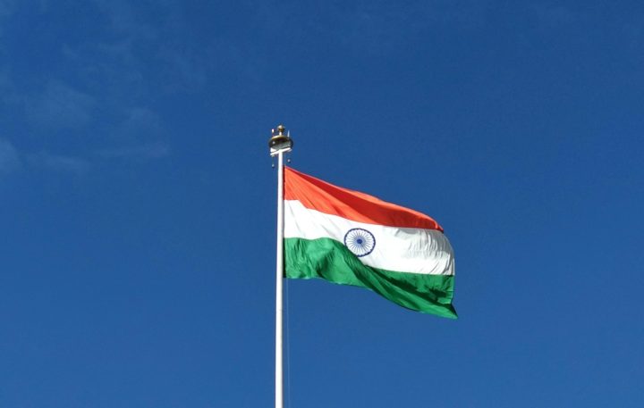 Flag of India waving in the breeze with a clear sky background.